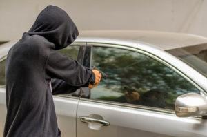 person pointing gun at vehicle